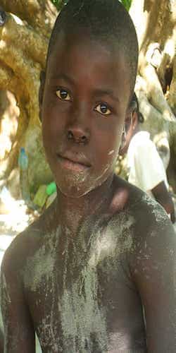 a young african boy with white powder on his face