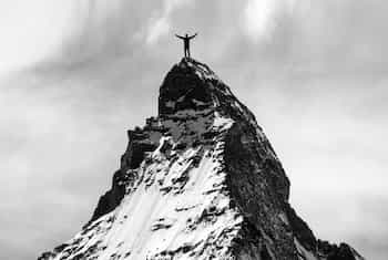 Man On Mountain Peak Man standing on the peak of a mountain